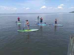 Image of five stand-up paddleboarders on the James River at CampFI Mid-Atlantic in May 2019. | The-Military-Guide.com