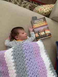 Image of Doug Nordman's granddaughter Arya at one month holding a copy of The Military Guide book | The-Military-Guide.com