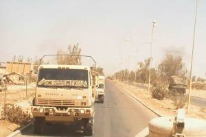Image of military vehicle in Middle East with windshield sign "One weekend a month my ass!" It's a sarcastic comment on the Reserve and National Guard drill routine of "one weekend a month and two weeks a year." | The-Military-Guide.com