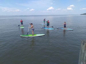 Image of Doug Nordmanand four other people on stand-up paddleboards at CampFI Mid-Atlantic in May 2019 on Virginia's James River. | The-Military-Guide.com