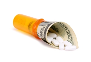 Medicare Part D prescription insurance premiums change nearly every year. Keep reviewing them annually. Image of a Medicare Part D prescription pill bottle with white tablets rolled inside a $100 bill | MilitaryFinancialIndependence.com
